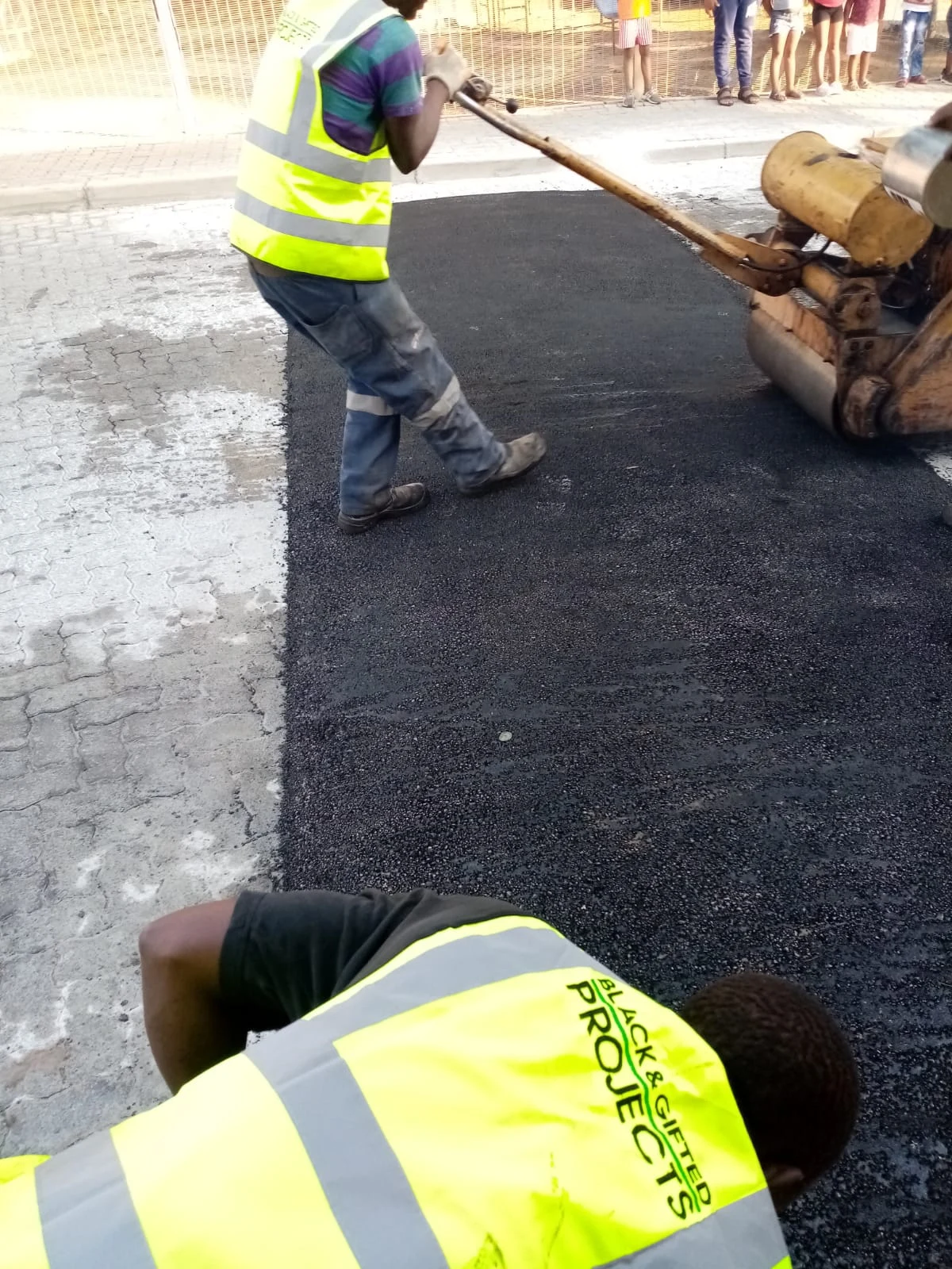 Roller compaction and hand finishing of an asphalt patch
